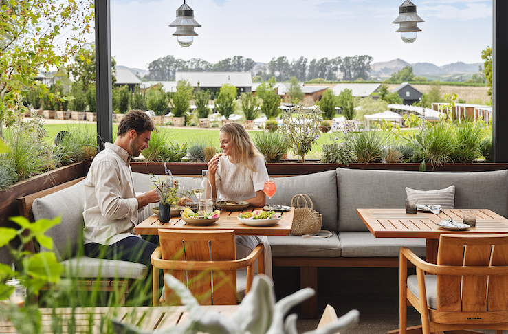 Man and woman sitting outside eating a meal