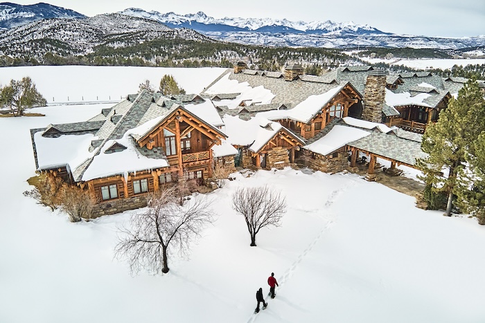 Two people snowshoeing outside lodge