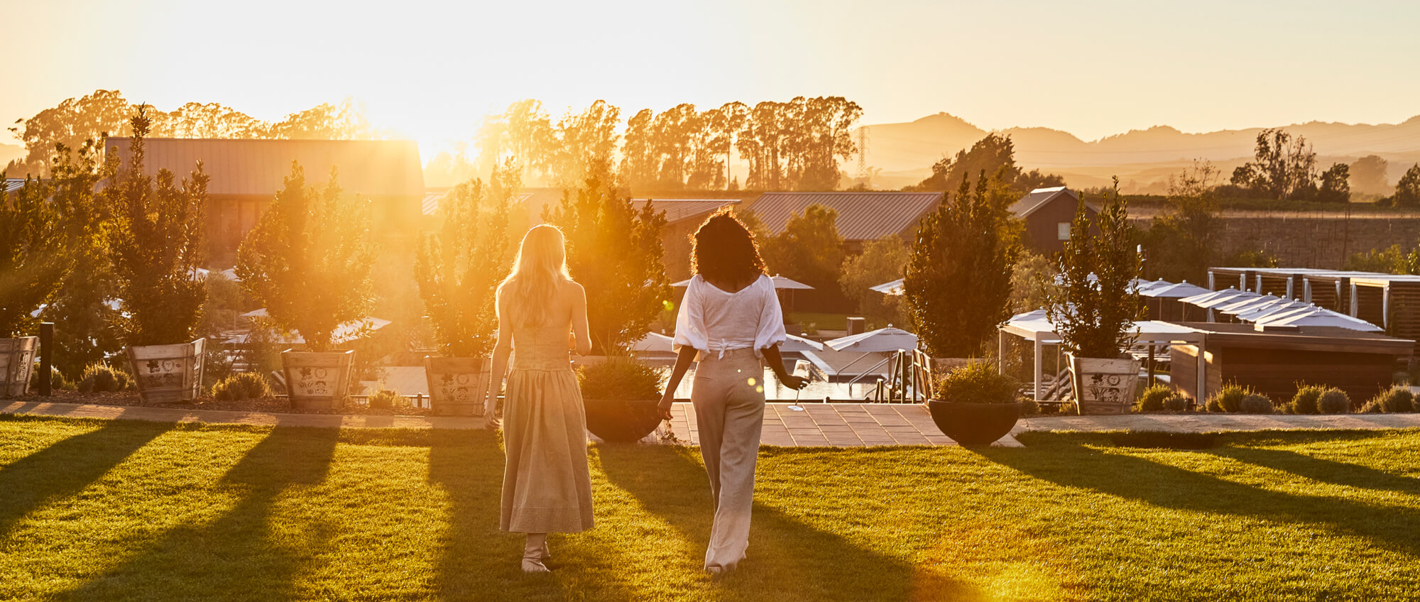 Two women walking into the sunset at Stanly Ranch, Napa Valley
